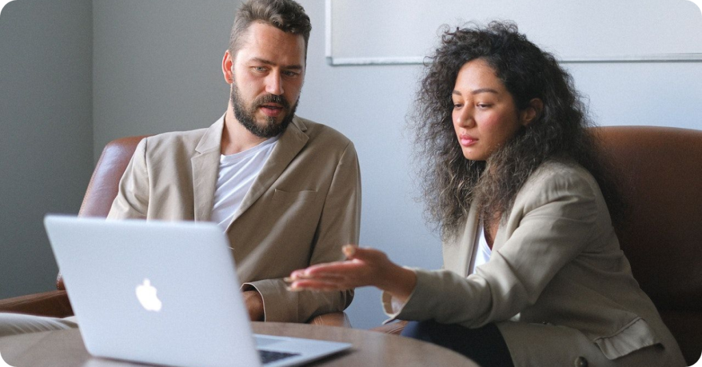 A man and a woman watching something on the screen